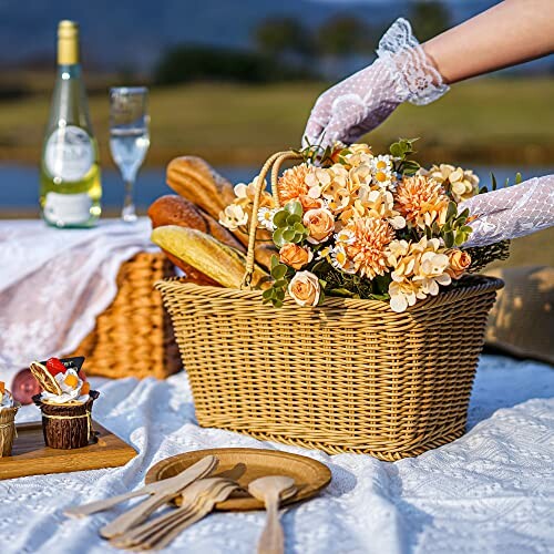 Picnic basket with flowers, bread, and a hand in lace glove.