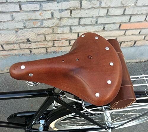 Vintage leather bicycle seat on a bike against a brick wall