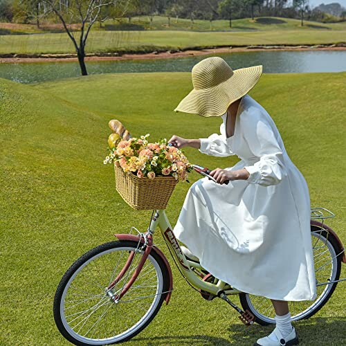 Woman in white dress and hat riding a bicycle with a flower basket